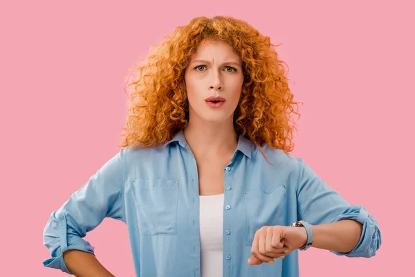 Attractive worried girl with wristwatch isolated on pink — Stock Photo