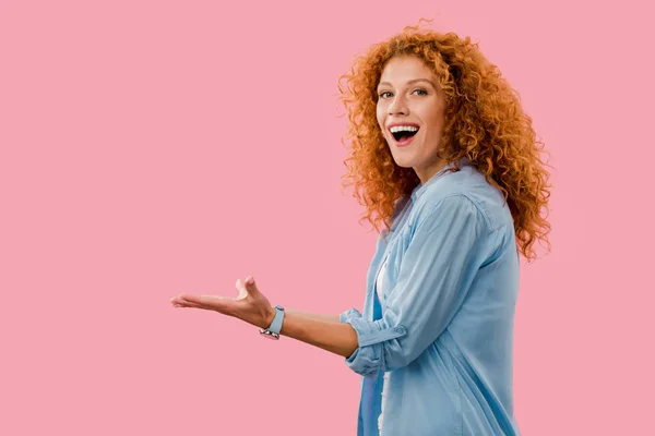 Smiling redhead woman gesturing Isolated On pink — Stock Photo