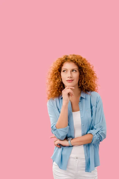 Attractive pensive redhead woman isolated on pink — Stock Photo
