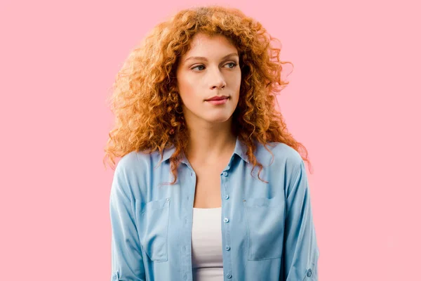 Attractive serious redhead girl isolated on pink — Stock Photo