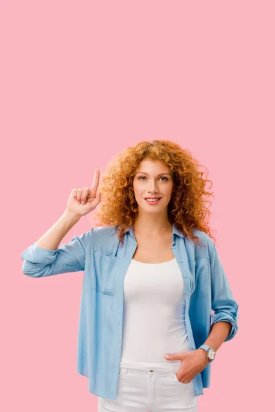 Smiling girl pointing up and having idea isolated on pink — Stock Photo
