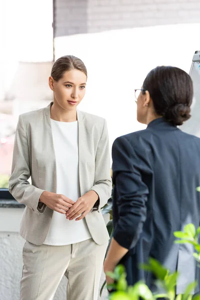 Zwei Kollegen in offizieller Kleidung, die sich im Büro anschauen — Stockfoto