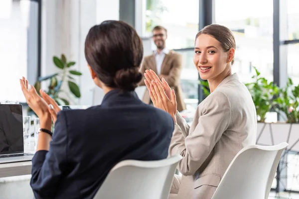 Businesswomen in formal wear applauding during conference in office — Stock Photo