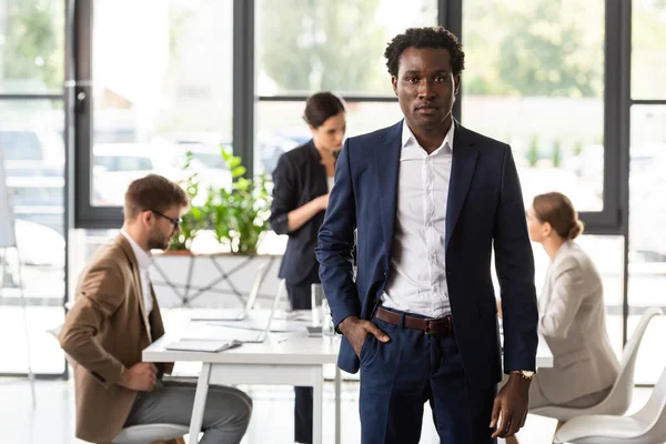 Vue de face de l'homme d'affaires afro-américain en tenue formelle debout avec la main dans la poche dans le bureau — Photo de stock