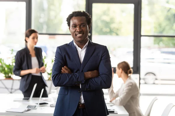 Frontansicht eines lächelnden afrikanisch-amerikanischen Geschäftsmannes in offizieller Kleidung im Büro — Stockfoto