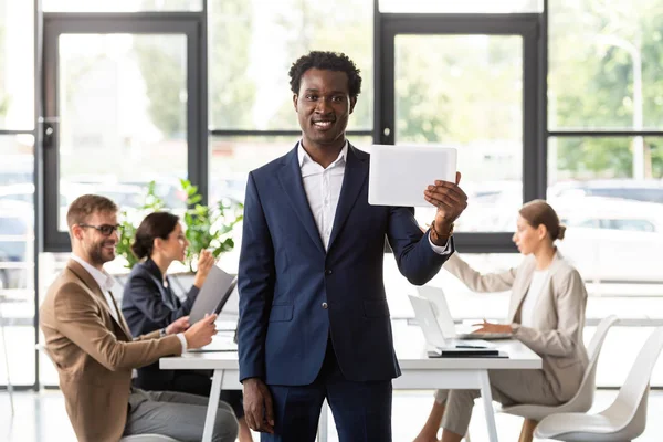 Вид спереду афроамериканського бізнесмена у формальному носінні, що тримає цифровий планшет в офісі — стокове фото
