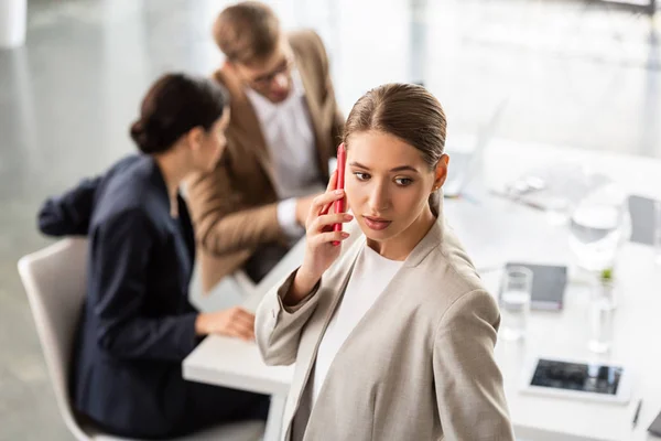 Geschäftsfrau in offizieller Kleidung spricht im Büro auf Smartphone — Stockfoto