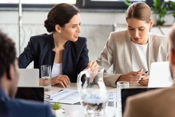 Vista parziale degli imprenditori in abito formale a tavola durante la conferenza in ufficio — Foto stock