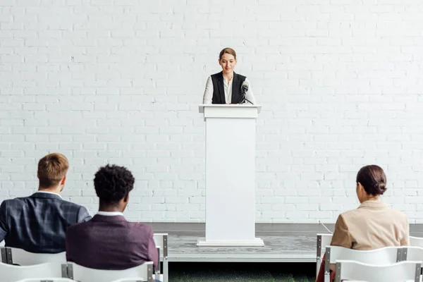 Приваблива бізнес-леді стоячи і розмовляючи під час конференц-залу — стокове фото