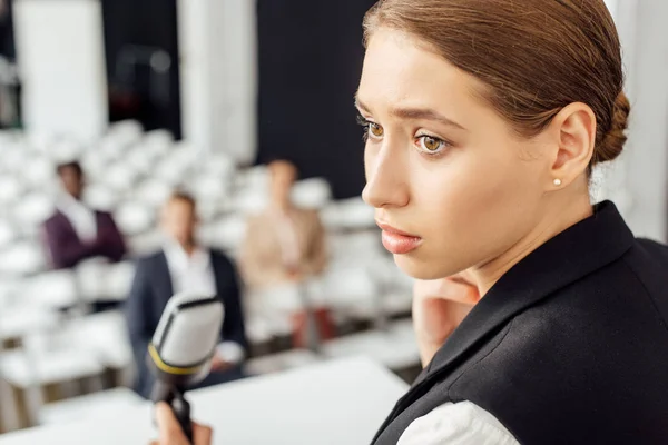 Selective focus of attractive businesswoman looking away during conference — Stock Photo