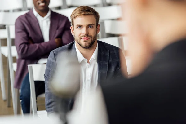 Foco seletivo do empresário no desgaste formal sentado durante a conferência — Fotografia de Stock