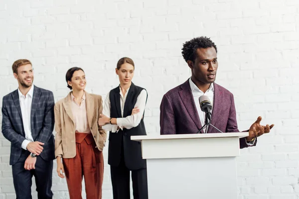 Homme d'affaires afro-américain en tenue de cérémonie parlant pendant la conférence — Photo de stock