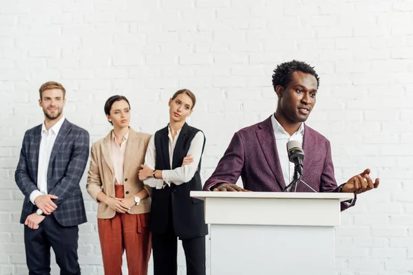 Homme d'affaires afro-américain en tenue de cérémonie parlant pendant la conférence — Photo de stock