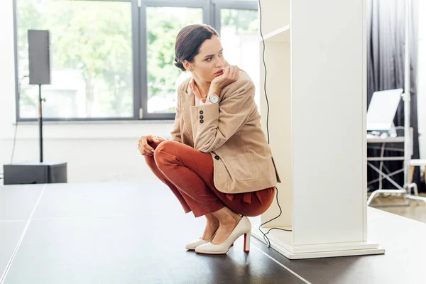 Attractive and scared businesswoman in formal wear sitting on floor — Stock Photo