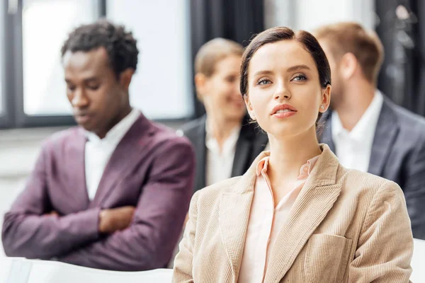 Selective focus of attractive woman in formal wear looking away during conference — Stock Photo