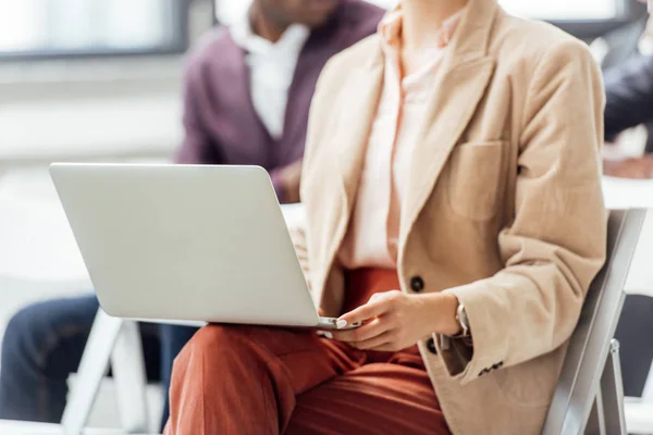 Cropped view of woman in formal wear holding laptop during conference — Stock Photo