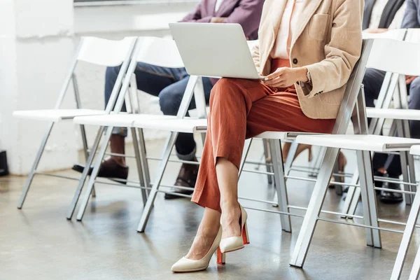 Abgeschnittene Ansicht einer Frau in formeller Kleidung mit Laptop während der Konferenz — Stockfoto