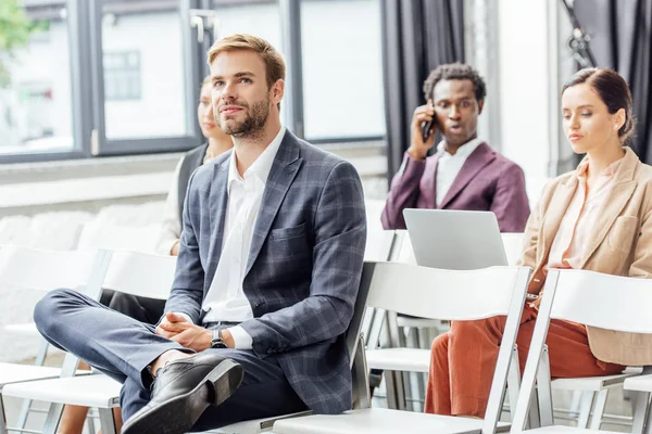 Quatre collègues multiethniques en tenue de cérémonie assis pendant la conférence — Photo de stock