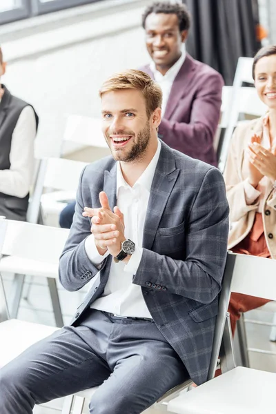 Quatre collègues multiethniques en tenue de cérémonie applaudissent pendant la conférence — Photo de stock