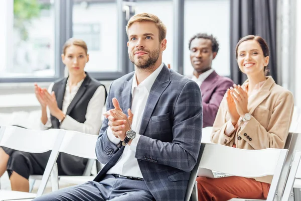 Selective focus of businessman in formal wear clapping during conference — Stock Photo