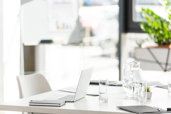 Oficina con mesa, silla, planta verde y dispositivo digital - foto de stock