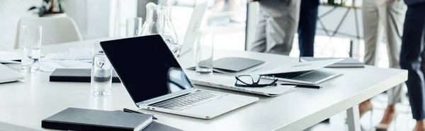 Panoramic shot of table with digital devices and notebooks — Stock Photo