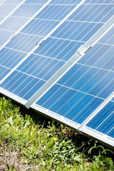 Green grass and blue solar energy batteries with copy space — Stock Photo