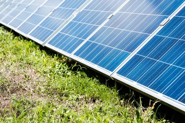 Blue solar energy batteries with copy space and green grass — Stock Photo