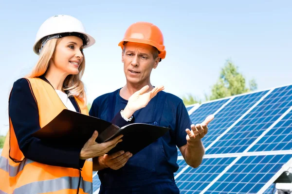 Gut aussehende Ingenieurin und Geschäftsfrau reden und halten Ordner — Stockfoto