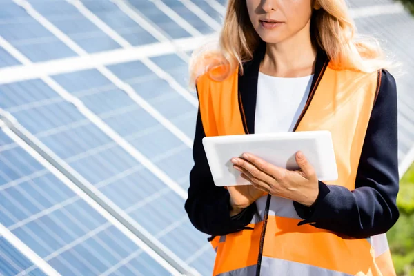 Vista recortada de la mujer de negocios en chaleco de seguridad utilizando tableta digital - foto de stock