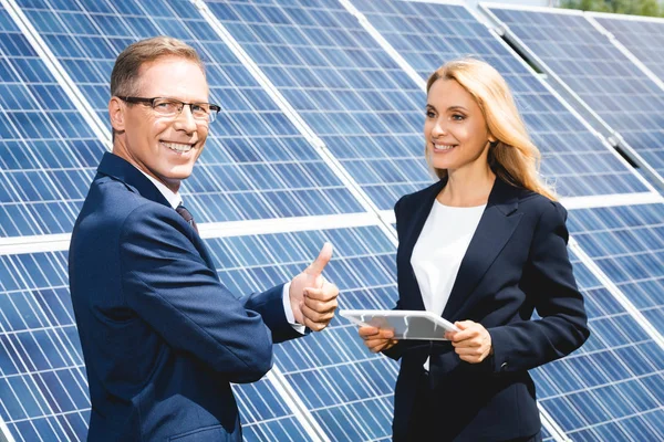 Handsome businessman showing thumb up and businesswoman holding digital tablet — Stock Photo