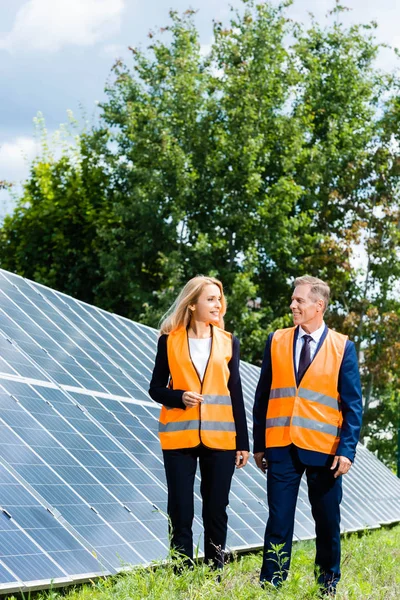 Handsome businessman and attractive businesswoman walking and looking at each other — Stock Photo