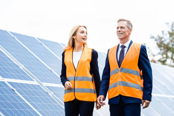Guapo hombre de negocios y atractiva mujer de negocios hablando y mirando hacia otro lado — Stock Photo