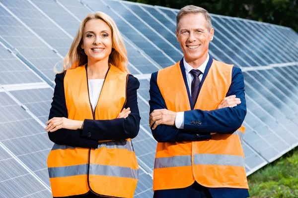 Guapo hombre de negocios y atractiva mujer de negocios sonriendo y mirando a la cámara - foto de stock