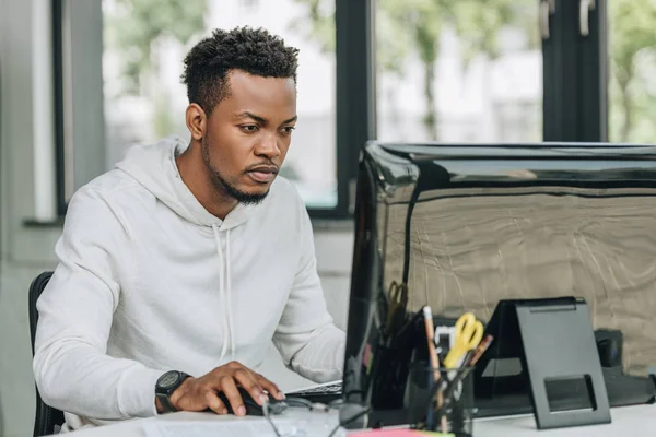 Programmeur afro-américain attentif travaillant sur ordinateur au bureau — Photo de stock