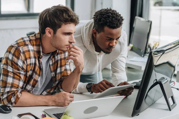 Two thoughtful multicultural programmers working at workplace together — Stock Photo