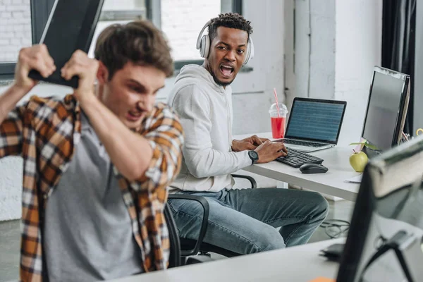Selective focus of african american programming yelling at angry colleague — Stock Photo