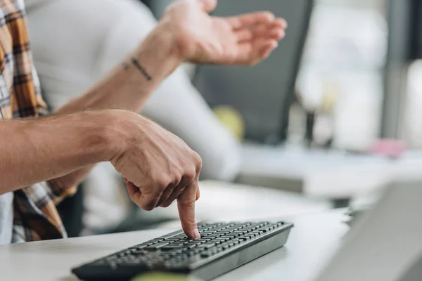 Cropped view of programmer gesturing while pressing key on keyboard — Stock Photo