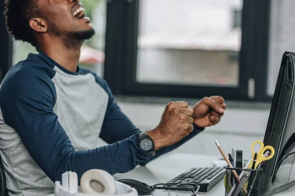 Irritado programador afro-americano gesticular enquanto sentado no local de trabalho no escritório — Fotografia de Stock