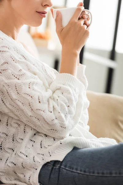 Vue recadrée de la femme en pull blanc tenant tasse — Photo de stock