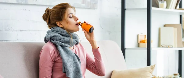 Foto panorámica de la mujer enferma con bufanda gris beber jarabe para la tos - foto de stock