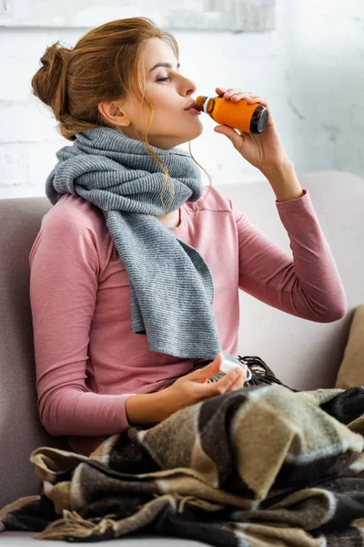 Attraente e malata donna con sciroppo grigio sciarpa bere tosse — Foto stock