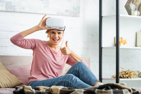 Mulher atraente com fone de ouvido realidade virtual mostrando polegar para cima — Fotografia de Stock