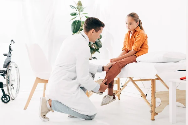 Kinderarzt im weißen Kittel untersucht Kind in Klinik — Stockfoto