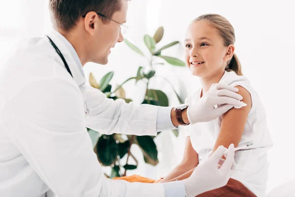 Pediatrist in latex gloves doing injection to child — Stock Photo