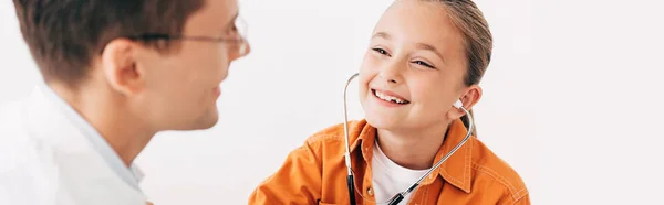 Panoramaaufnahme eines lächelnden Kindes mit Stethoskop und Kinderarzt isoliert auf Weiß — Stockfoto