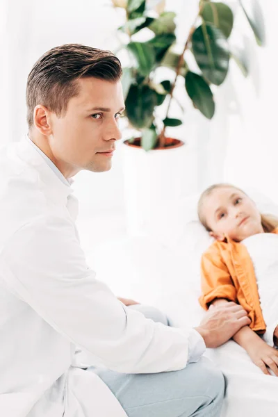 Kinderarzt im weißen Kittel untersucht Kind in Klinik — Stockfoto