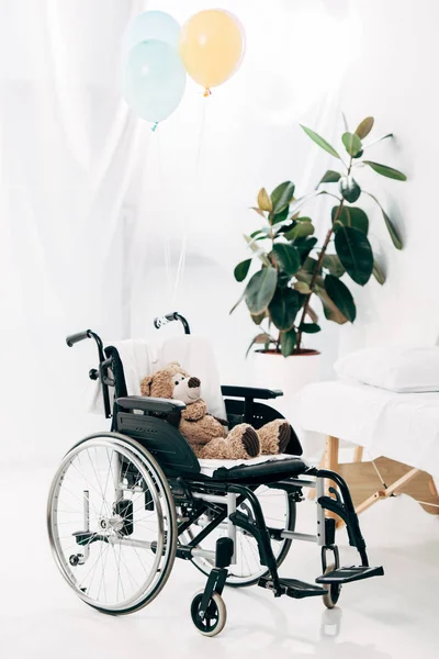 Ours en peluche sur fauteuil roulant et ballons à l'hôpital — Photo de stock
