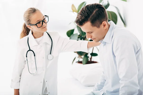 Child in glasses and doctor costume examining patient — Stock Photo