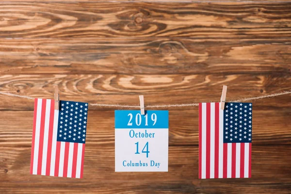 Kalender mit 14 Oktober Datum zwischen den Nationalflaggen Amerikas auf hölzerner Oberfläche — Stockfoto